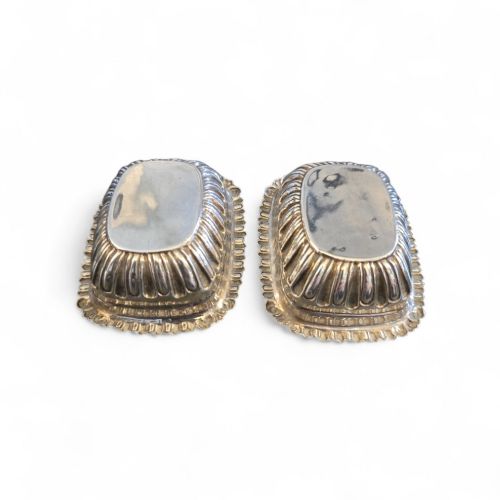 fig 2. A pair of Edwardian sterling silver rectangular open salt cellars featuring fluted sides, gadrooned rims, and gilded interiors.