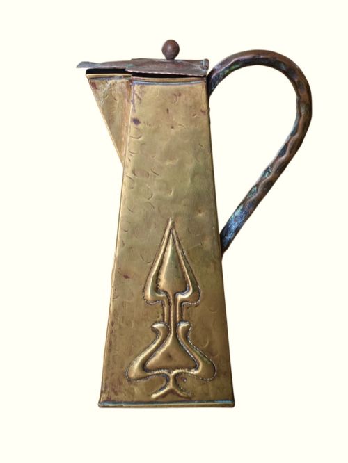 fig 1. A tapered square brass water jug with a fitted metal lid, curved handle, and embossed stylised Art Nouveau motifs on the sides.