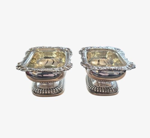 fig 1. A pair of Regency sterling silver rectangular table salts featuring gadrooned rims and gilded interiors on shaped pedestal bases.