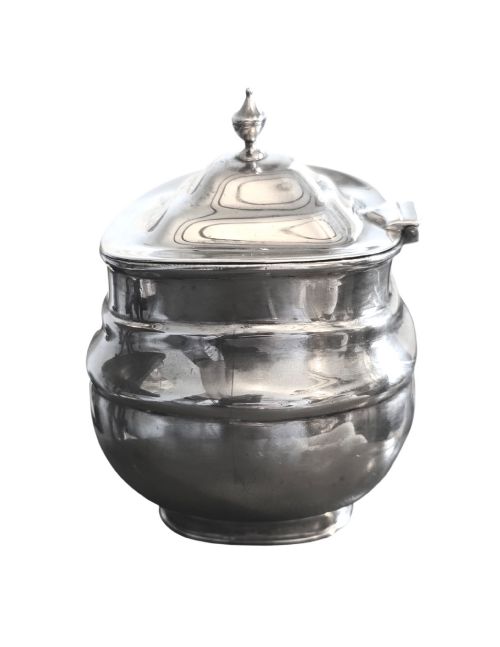 fig 1. An Edwardian sterling silver tea caddy featuring a bulbous body, stepped lid, and urn-shaped finial.