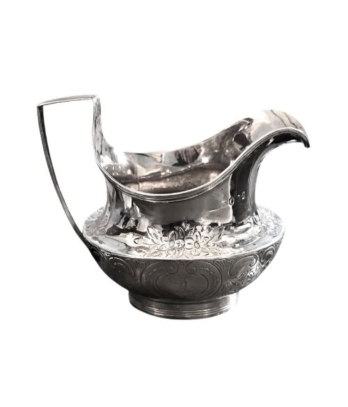 fig 2. A George III sterling silver cream jug with chased scroll decoration, an angular high loop handle, and a circular foot.