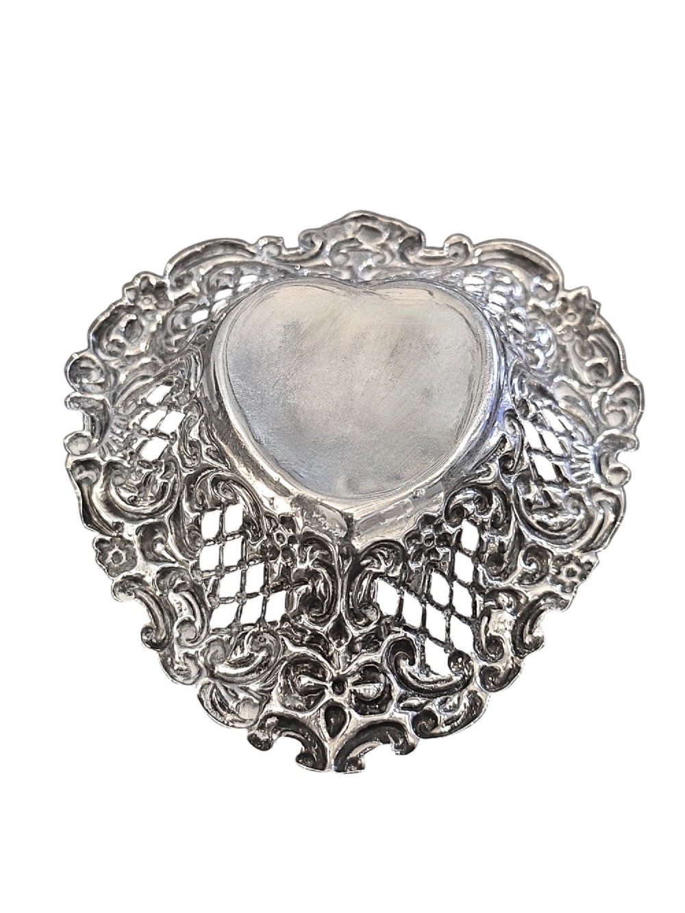 An Edwardian sterling silver heart-shaped bonbon dish featuring an ornate pierced lattice border with scrollwork and a smooth central reservoir. View II