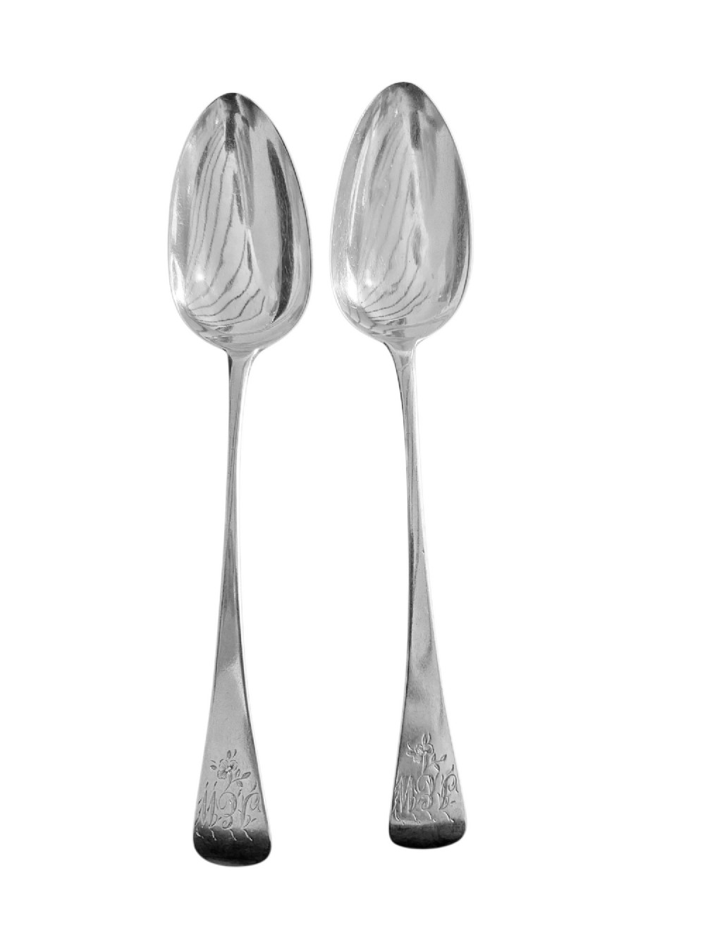 A pair of 1789 Georgian sterling silver serving spoons with oval bowls, long stems, and hand-engraved terminals.
