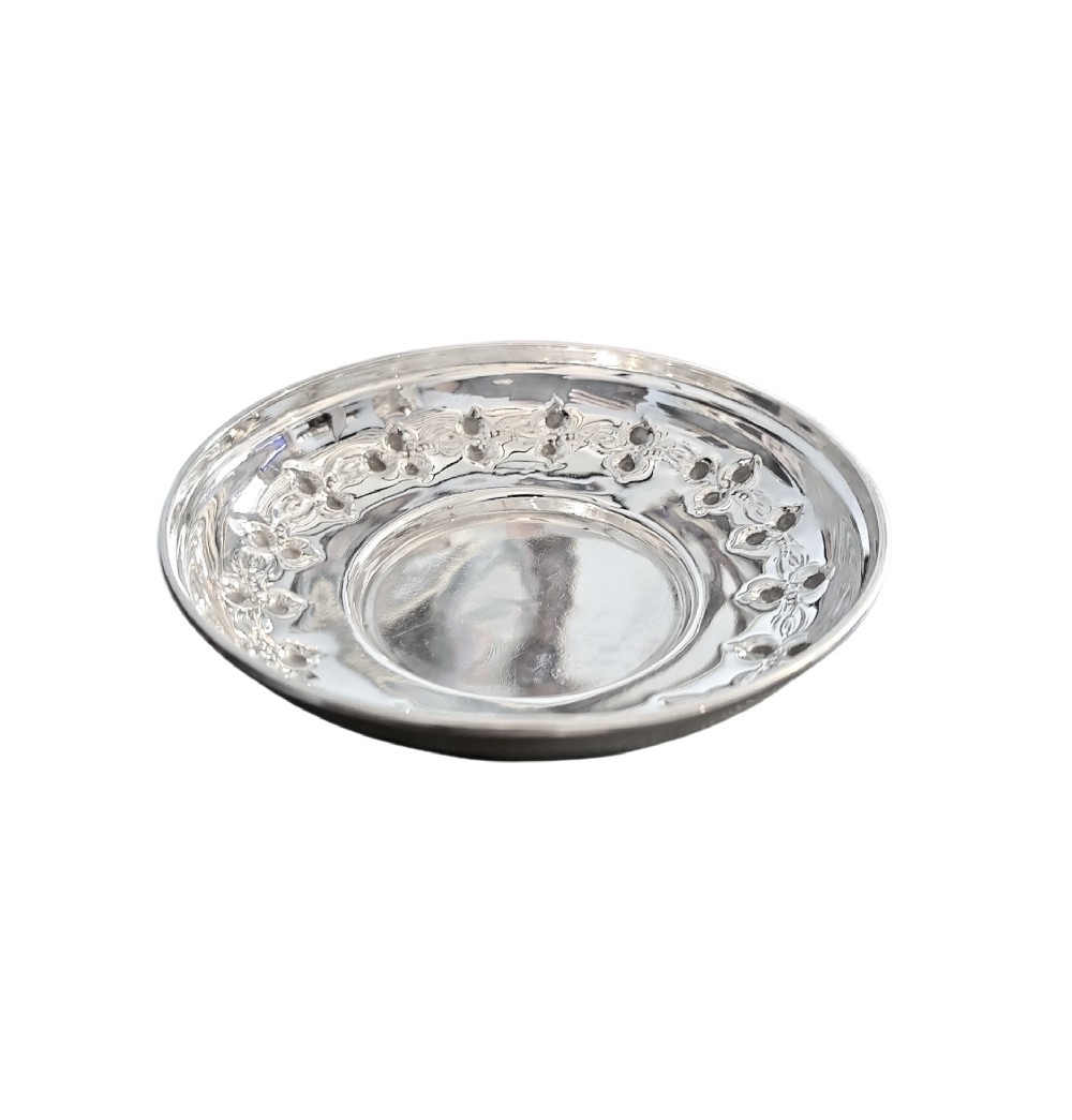 A small circular Edwardian sterling silver dish featuring a polished central well and a decorative pierced rim with geometric cut-outs.