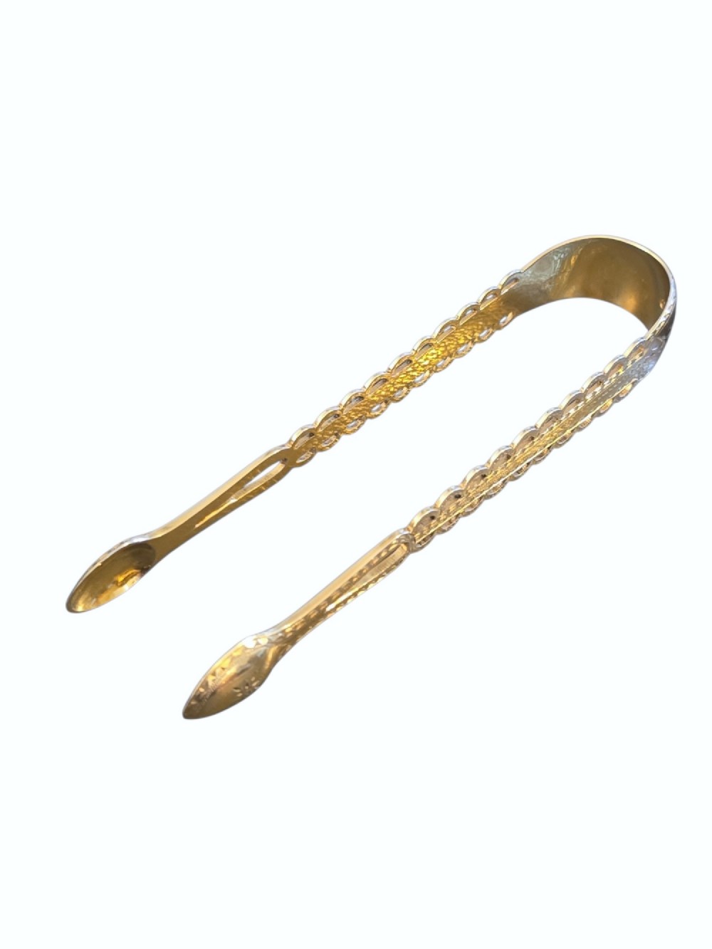 A pair of Victorian silver-gilt sugar tongs featuring decorative pierced arms and engraved spoon-shaped ends. View III