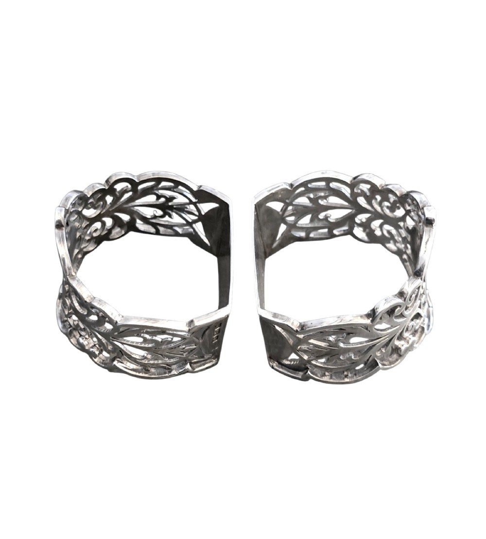 A pair of Edwardian pierced sterling silver napkin rings with unengraved cartouches presented in a dark velvet-lined fitted box. View IV