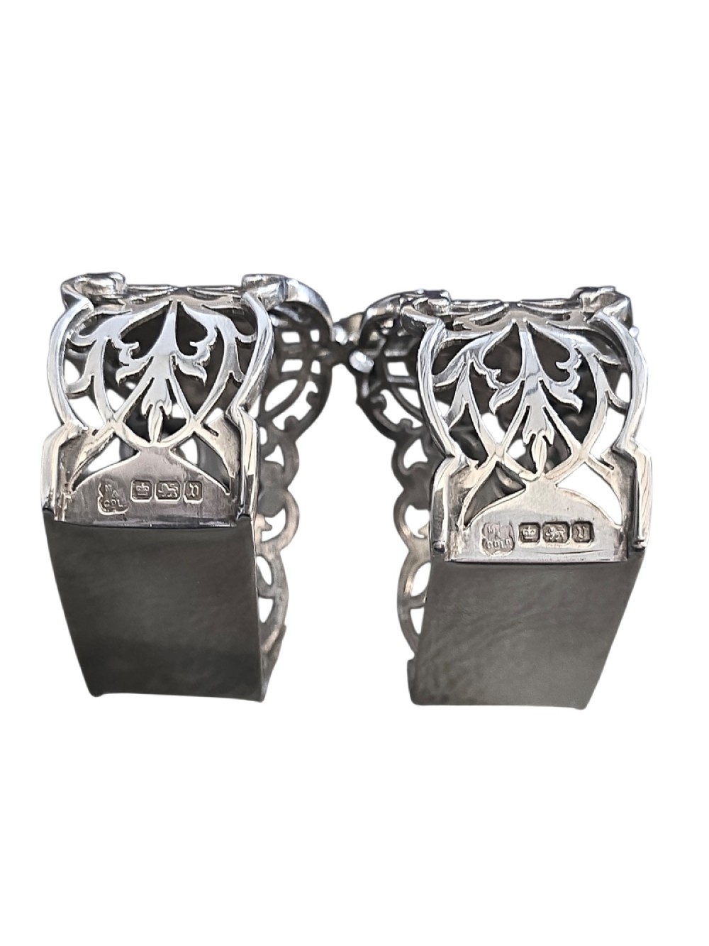 A pair of Edwardian pierced sterling silver napkin rings with unengraved cartouches presented in a dark velvet-lined fitted box. View VII