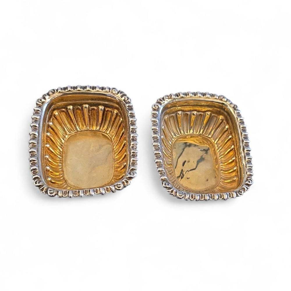 A pair of Edwardian sterling silver rectangular open salt cellars featuring fluted sides, gadrooned rims, and gilded interiors. View II