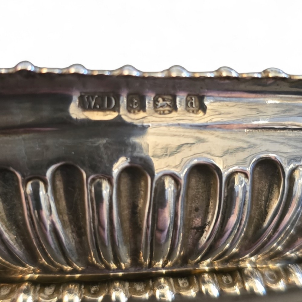 A pair of Edwardian sterling silver rectangular open salt cellars featuring fluted sides, gadrooned rims, and gilded interiors. View IV
