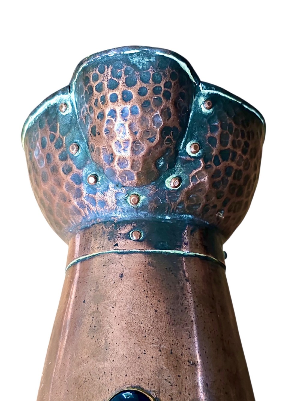 An antique Arts and Crafts copper jug featuring a planished finish, riveted collar, brass handle, and inset coloured cabochons. View VII