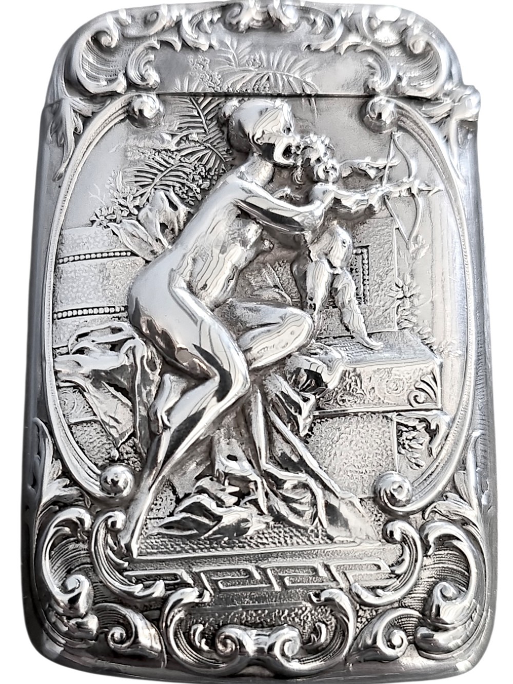 An Edwardian sterling silver vesta case featuring embossed relief detailing of Cupid and Psyche framed by scrollwork borders. View VI