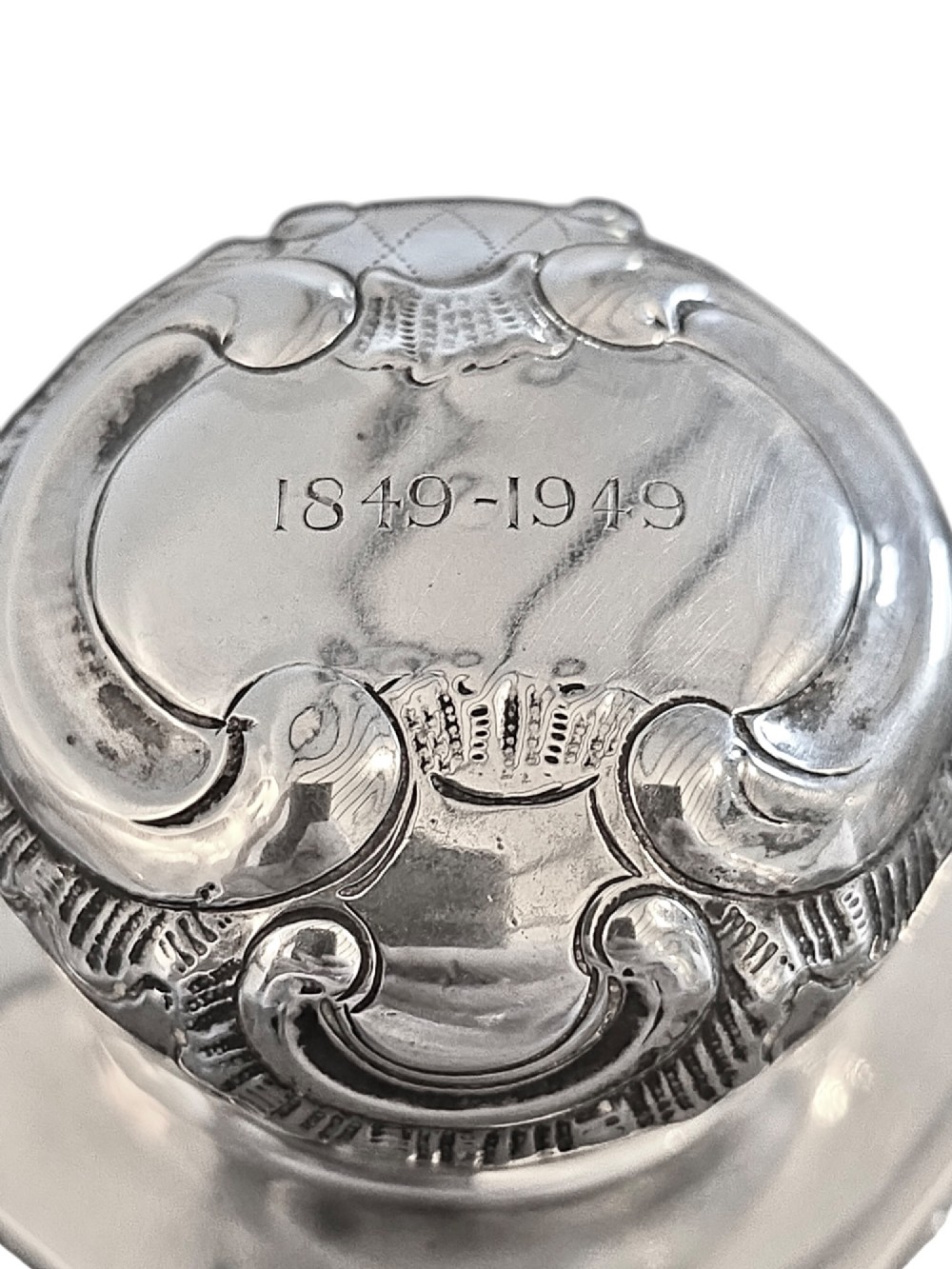 A late Victorian hexagonal sterling silver tea caddy featuring relief repousse work of cherubs, scrollwork, and floral motifs with a fitted domed lid. View V