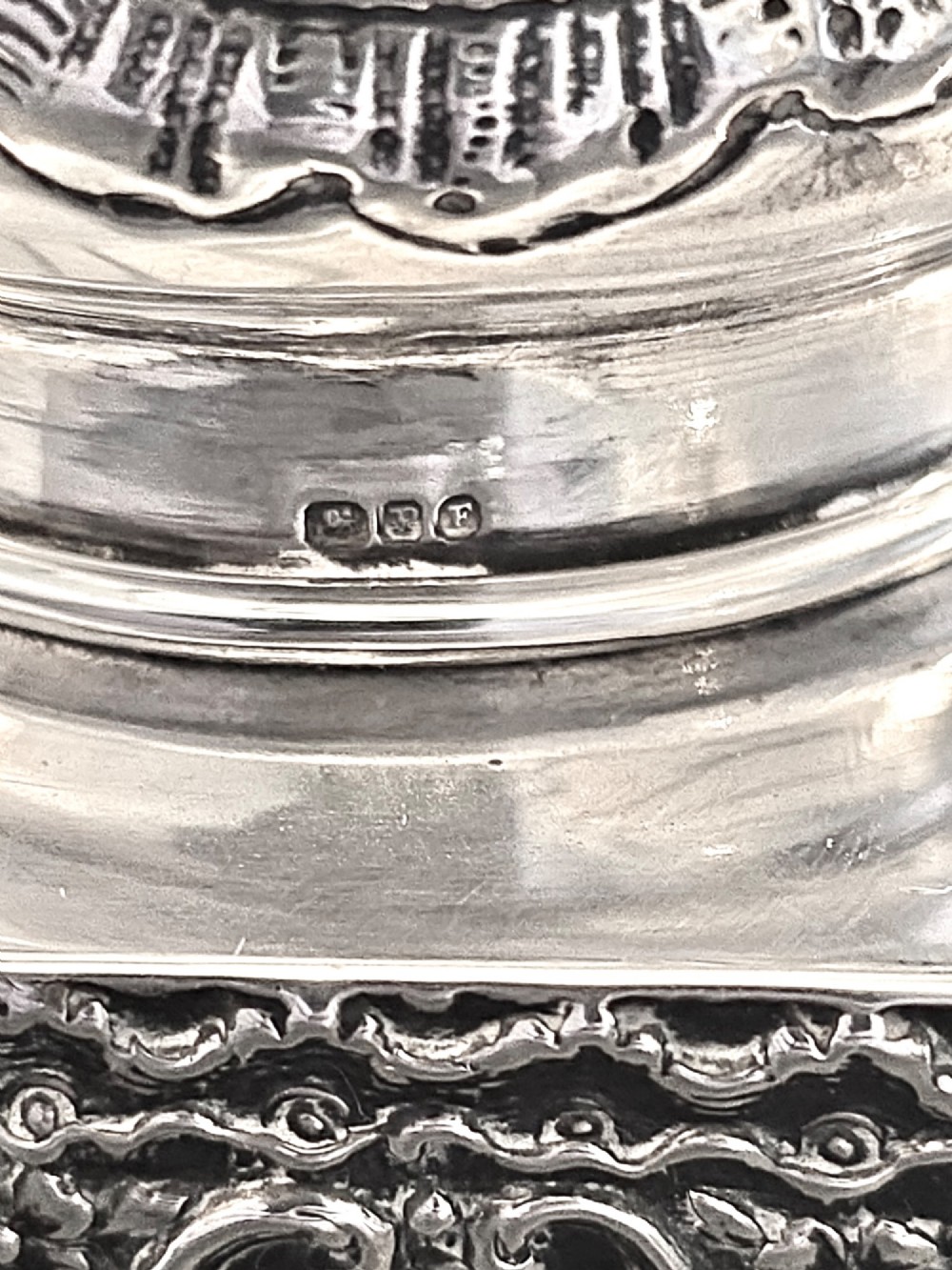 A late Victorian hexagonal sterling silver tea caddy featuring relief repousse work of cherubs, scrollwork, and floral motifs with a fitted domed lid. View VII