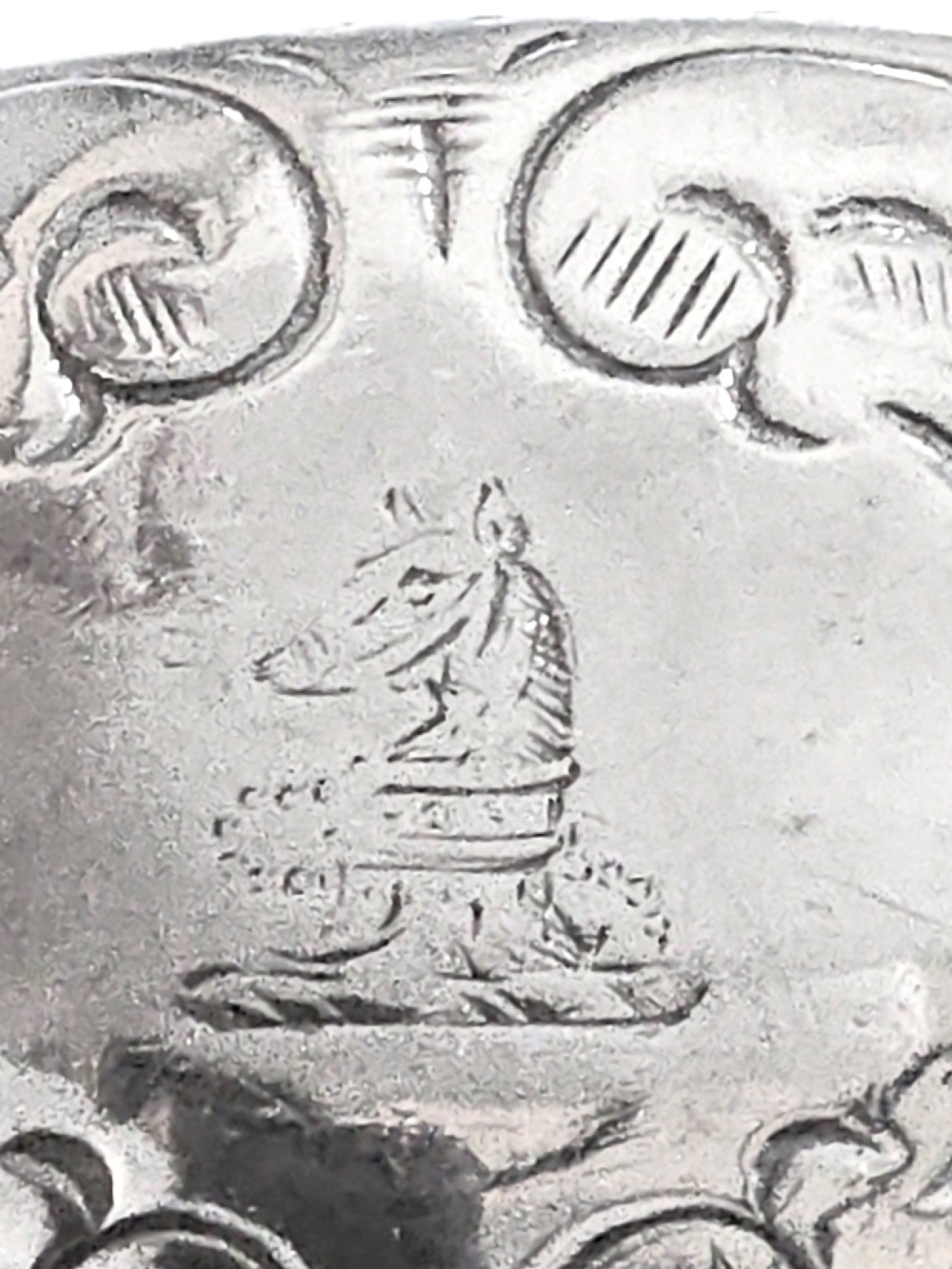 A George III sterling silver cream jug with chased scroll decoration, an angular high loop handle, and a circular foot. View VII