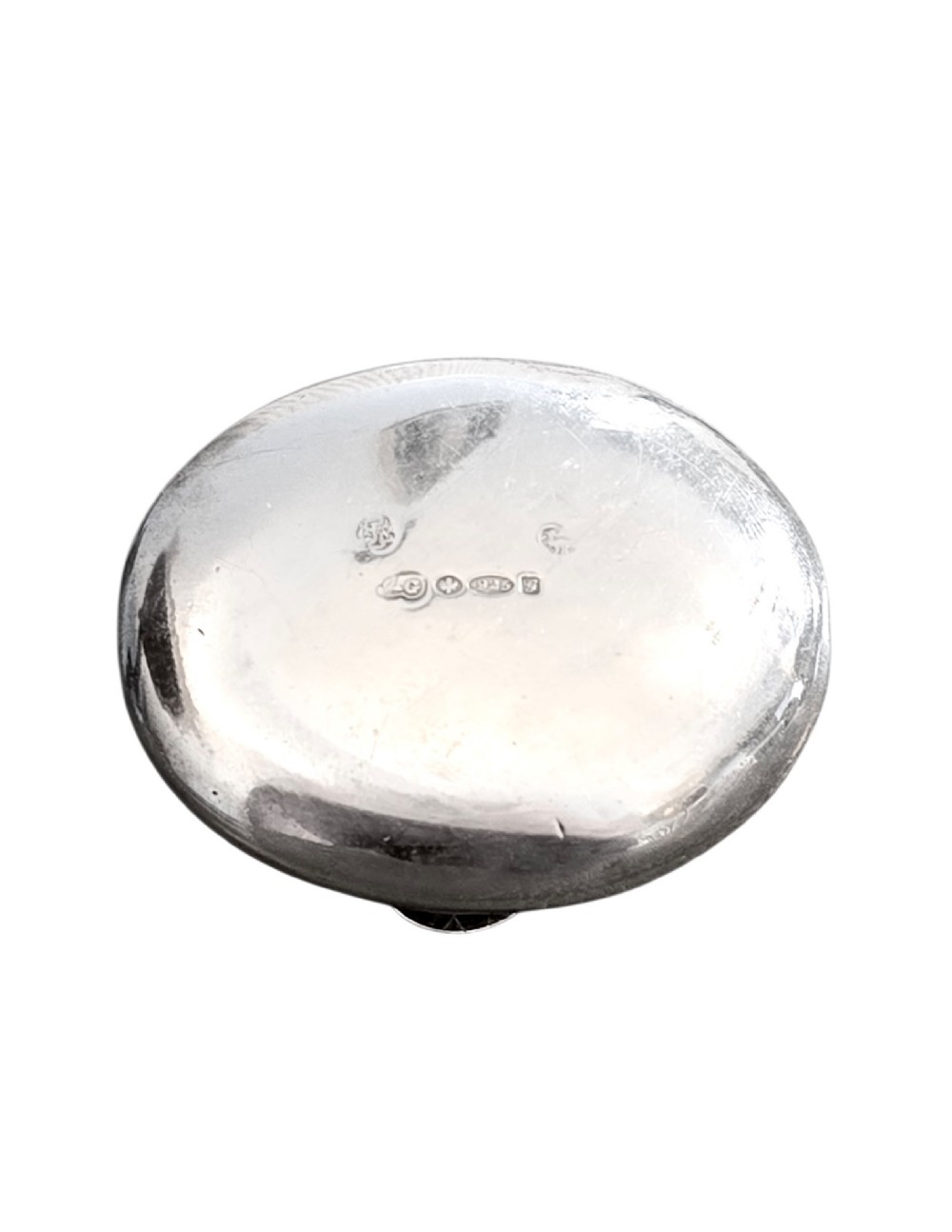An oval antique sterling silver snuff box featuring an embossed central scene of dancing figures, framed by scrollwork borders. View IV