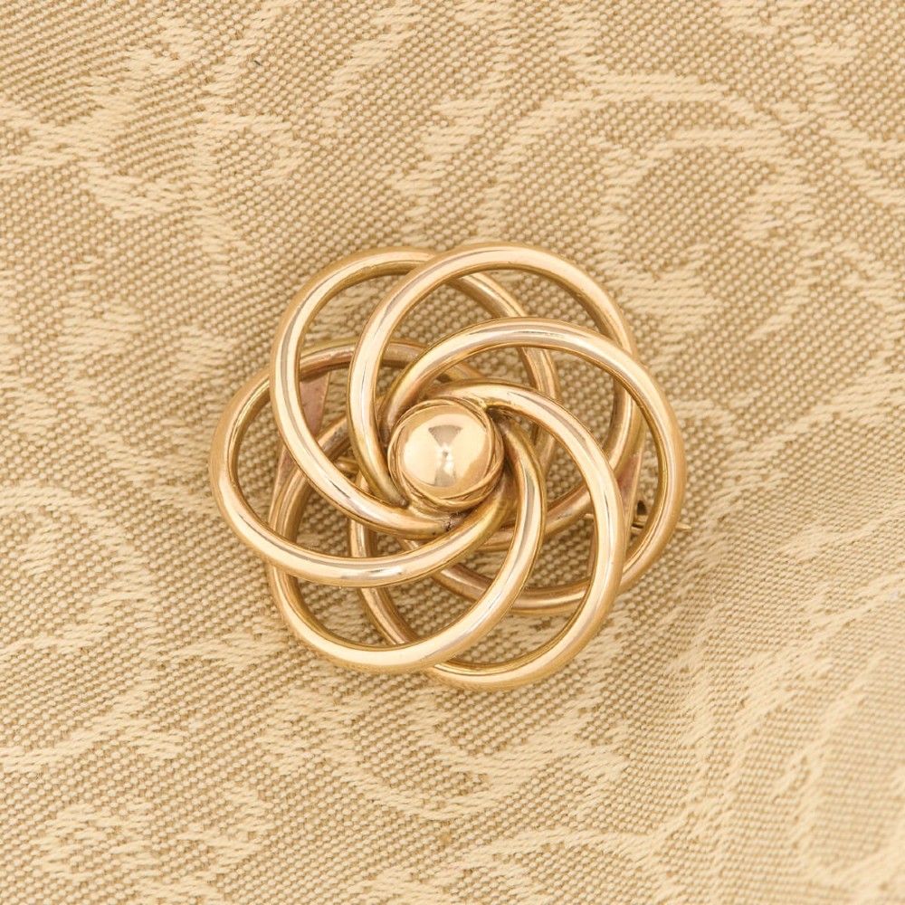 A 1950s 9ct yellow gold brooch featuring a central polished sphere surrounded by concentric swirling wire loops. View II