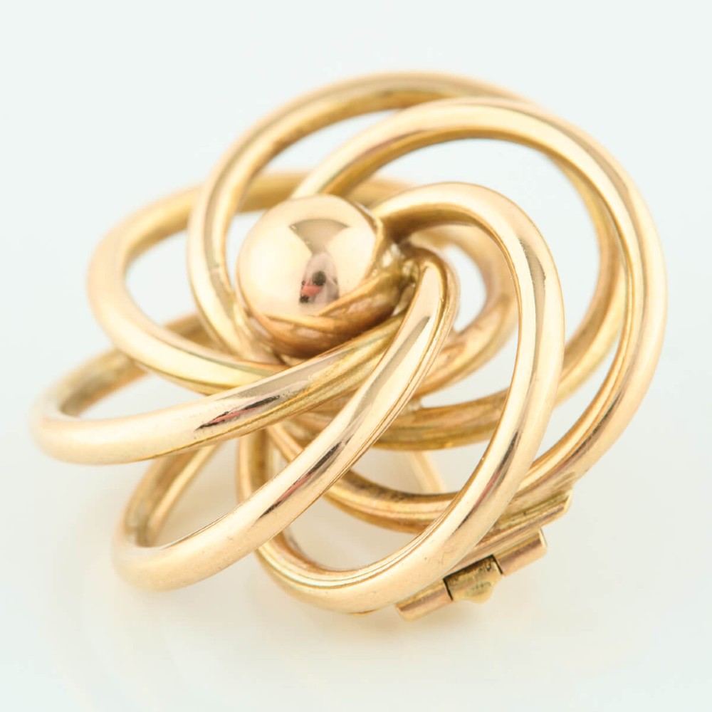 A 1950s 9ct yellow gold brooch featuring a central polished sphere surrounded by concentric swirling wire loops. View IV