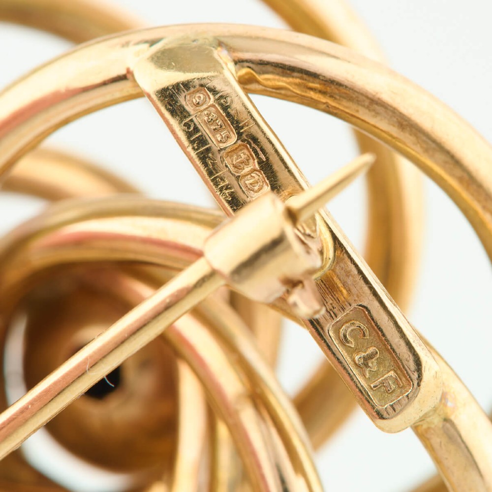 A 1950s 9ct yellow gold brooch featuring a central polished sphere surrounded by concentric swirling wire loops. View VII