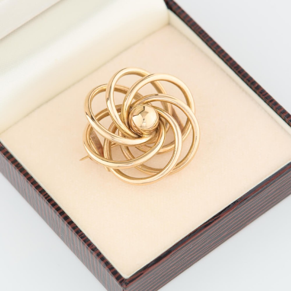 A 1950s 9ct yellow gold brooch featuring a central polished sphere surrounded by concentric swirling wire loops. View VIII