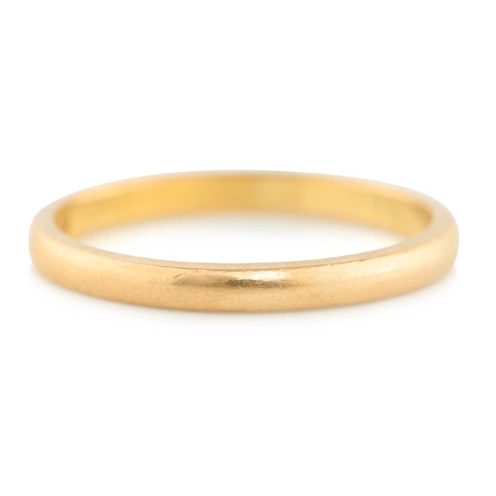 A plain 22ct yellow gold wedding band displaying a polished surface and classic rounded profile.