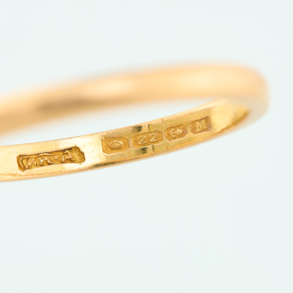 A plain 22ct yellow gold wedding band displaying a polished surface and classic rounded profile. View V