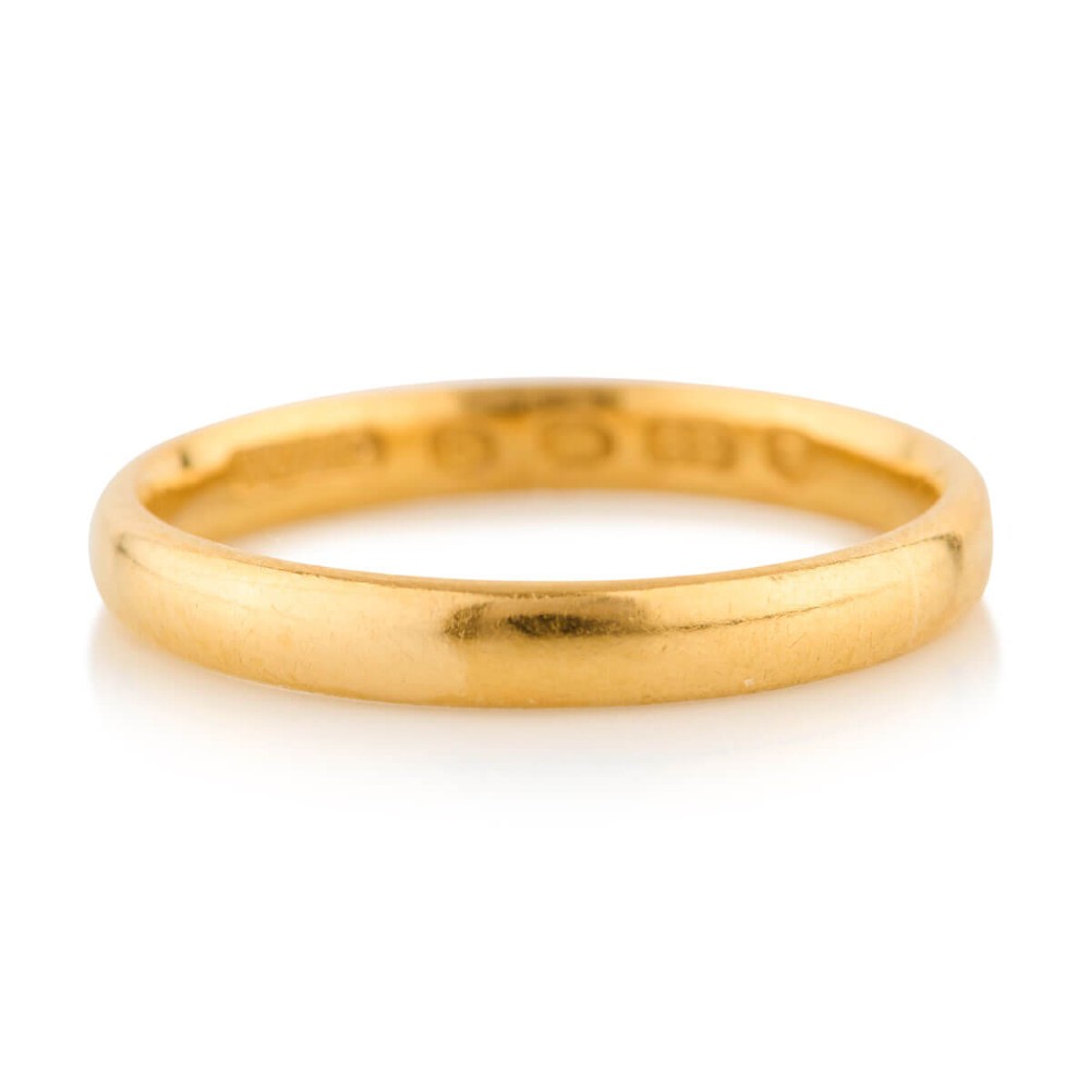 A plain 22ct yellow gold wedding band displaying interior hallmarks.