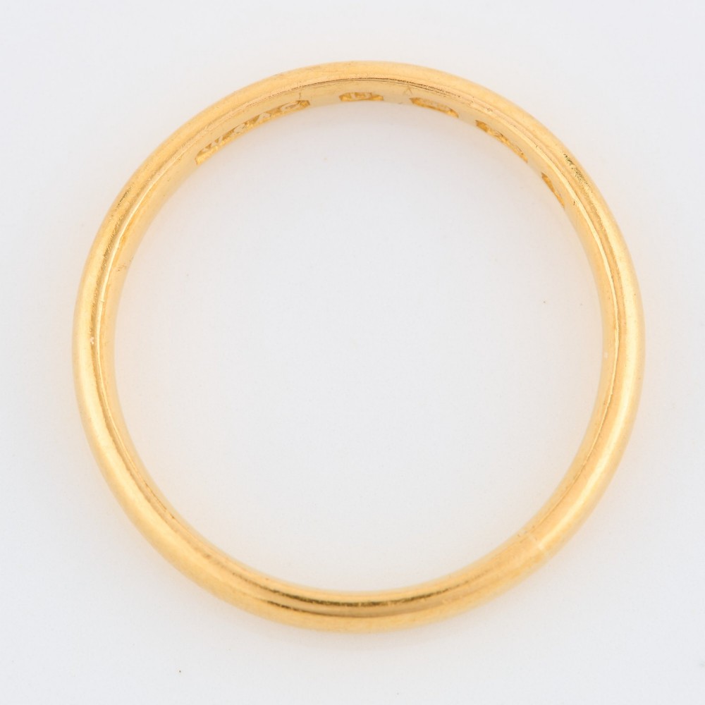 A plain 22ct yellow gold wedding band displaying interior hallmarks. View III
