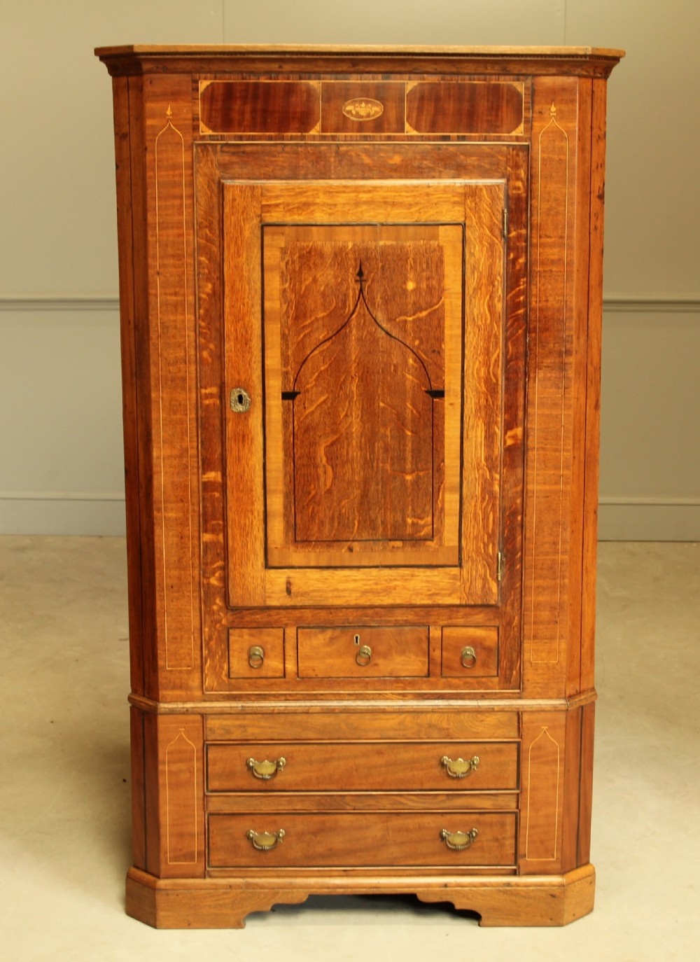 A GEORGE III OAK AND MAHOGANY CORNER CABINET.