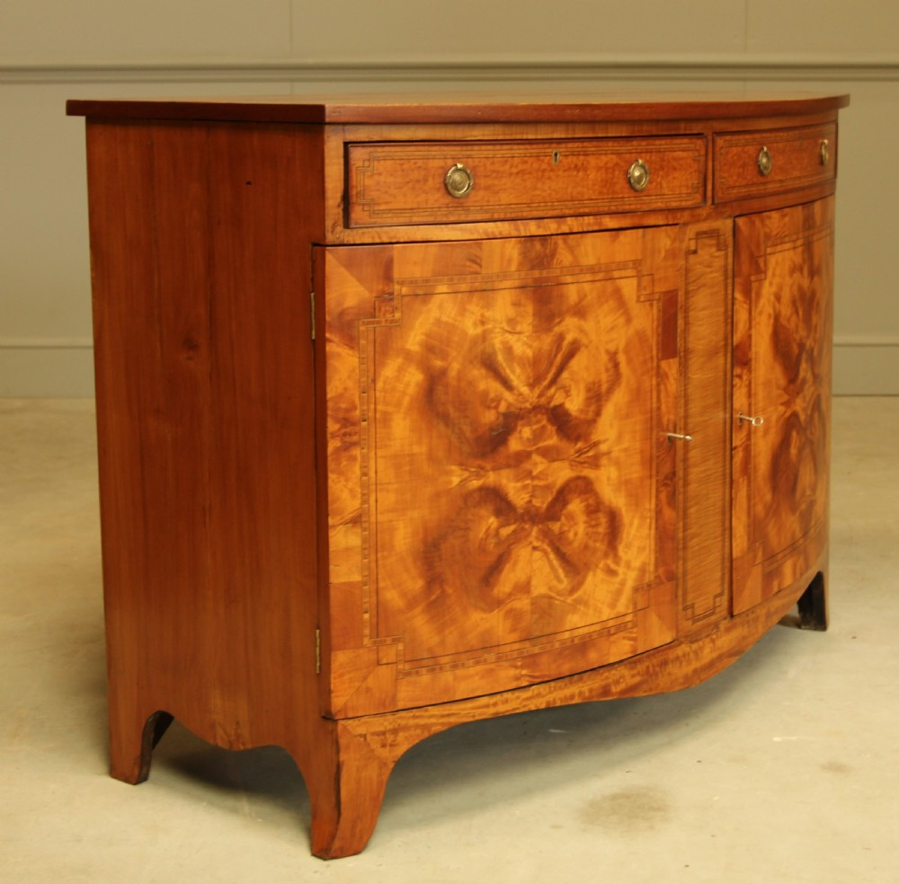 AN EDWARDIAN SATINWOOD BOW FRONTED TWO DOOR SIDEBOARD. View IV