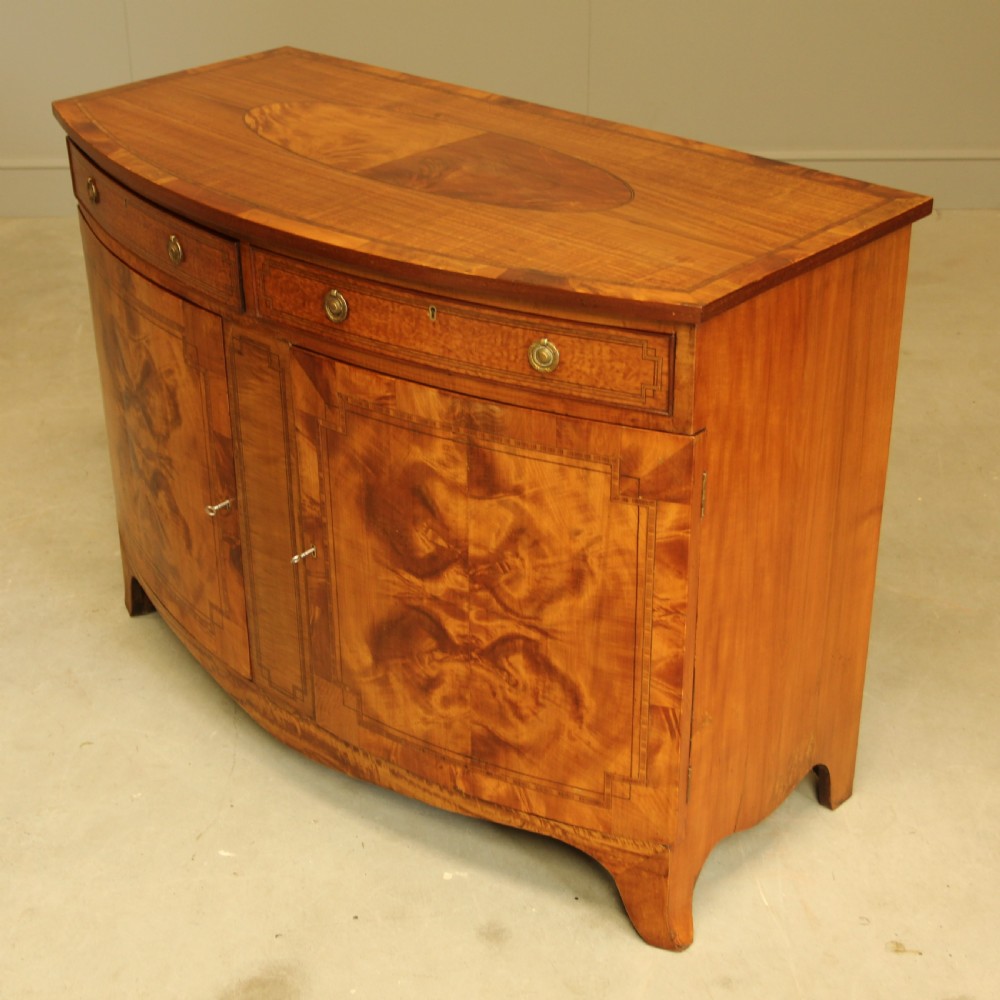 AN EDWARDIAN SATINWOOD BOW FRONTED TWO DOOR SIDEBOARD. View VI