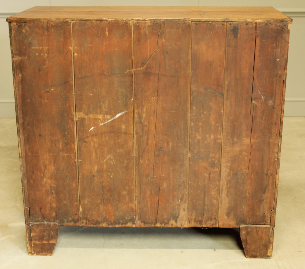 A Victorian flame mahogany chest of drawers featuring boxwood inlay, two short drawers over three long drawers, oval brass handles, and splayed bracket feet. View XI