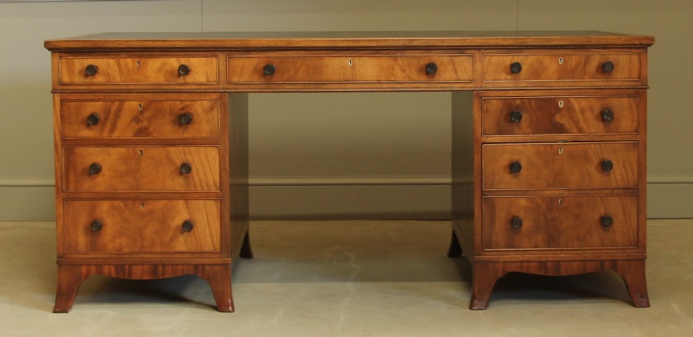 AN EARLY 20TH CENTURY CURL MAHOGANY PARTNERS DESK.