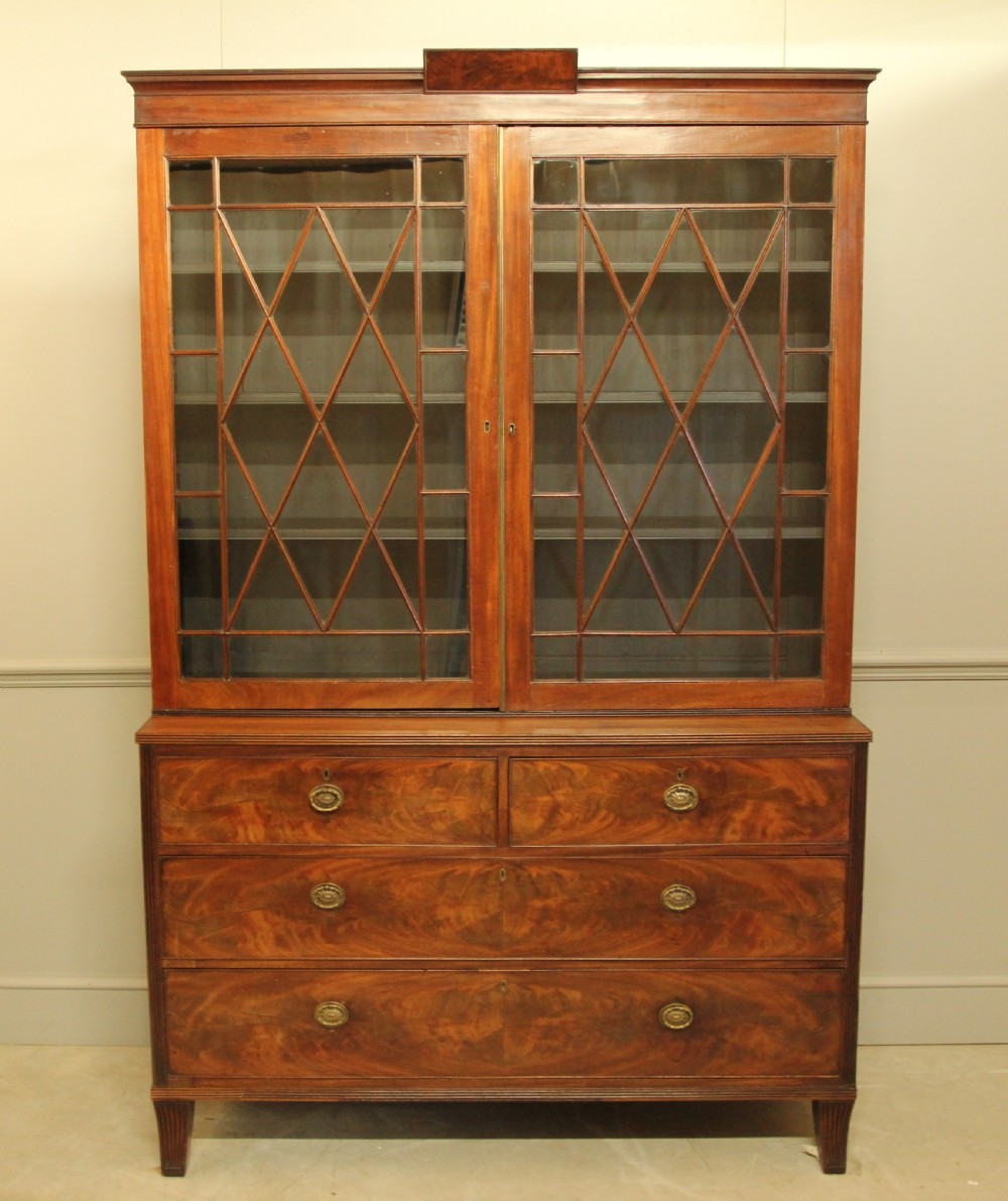 A 19TH CENTURY MAHOGANY BOOKCASE DISPLAY ON CHEST.