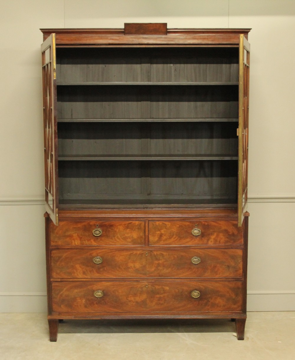 A 19TH CENTURY MAHOGANY BOOKCASE DISPLAY ON CHEST. View II
