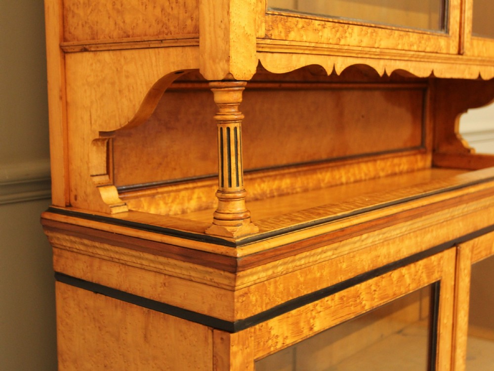 A two-tier Victorian display cabinet crafted from golden birds eye maple veneer with glazed double doors on both the upper and lower sections. View VI