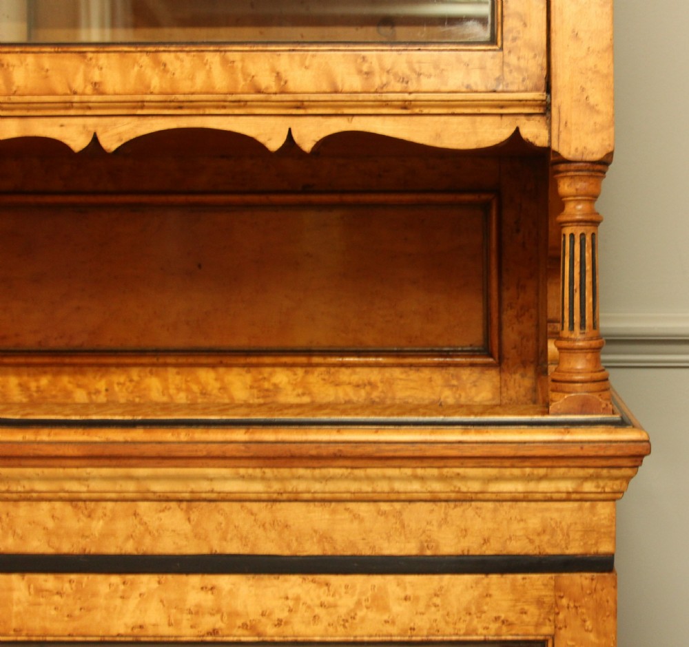 A two-tier Victorian display cabinet crafted from golden birds eye maple veneer with glazed double doors on both the upper and lower sections. View IX