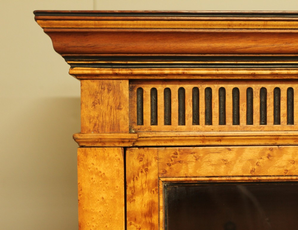 A two-tier Victorian display cabinet crafted from golden birds eye maple veneer with glazed double doors on both the upper and lower sections. View XI