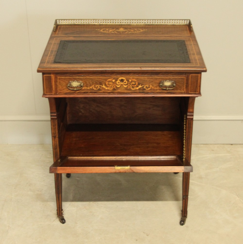 A Victorian rosewood Davenport desk featuring fine floral marquetry inlay, a black leather writing surface, a brass gallery rail, and slender tapered legs on brass castors. View VIII