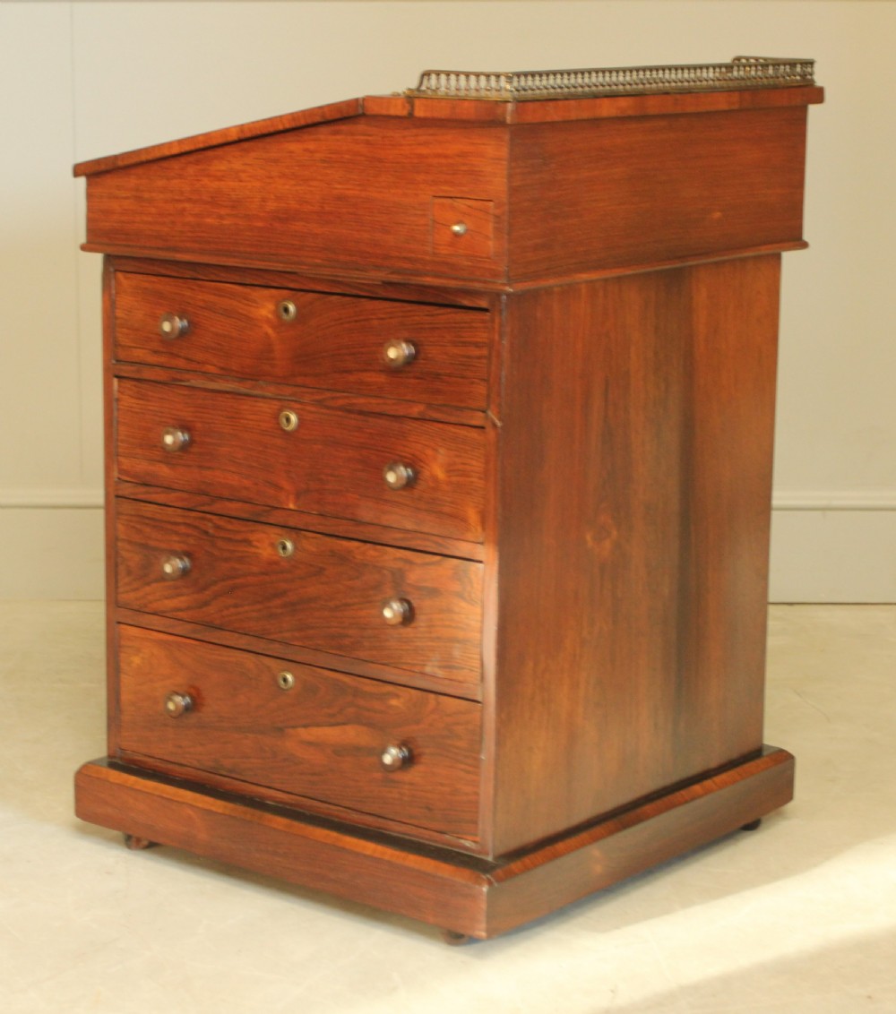 An early 19th-century rosewood Davenport desk featuring a slanted leather-inset writing surface, brass top gallery rail, and side drawers. View VIII