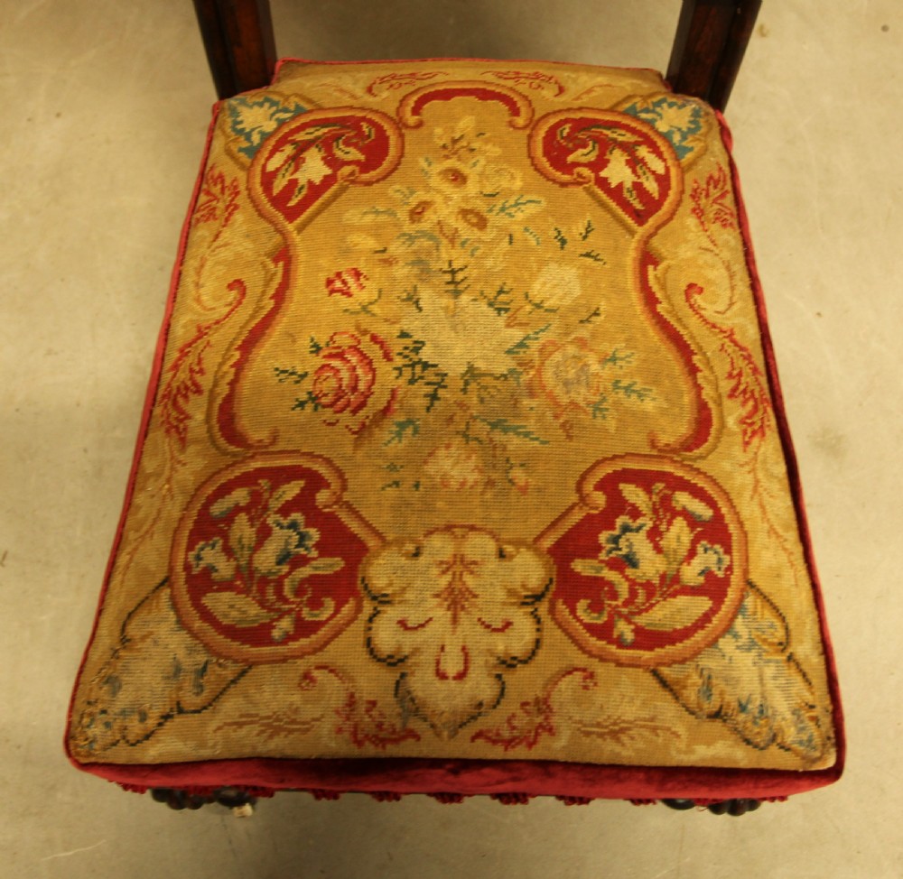 A 19th-century carved rosewood side chair featuring heraldic needlepoint upholstery on the backrest, a floral tapestry seat with red velvet borders, turned front legs, and castors. View VIII