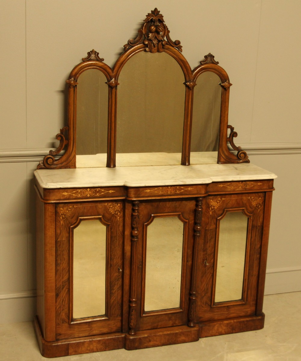 A Victorian burr walnut credenza with a white marble top, arched tri-fold mirror back, and three mirrored cabinet doors below. View II