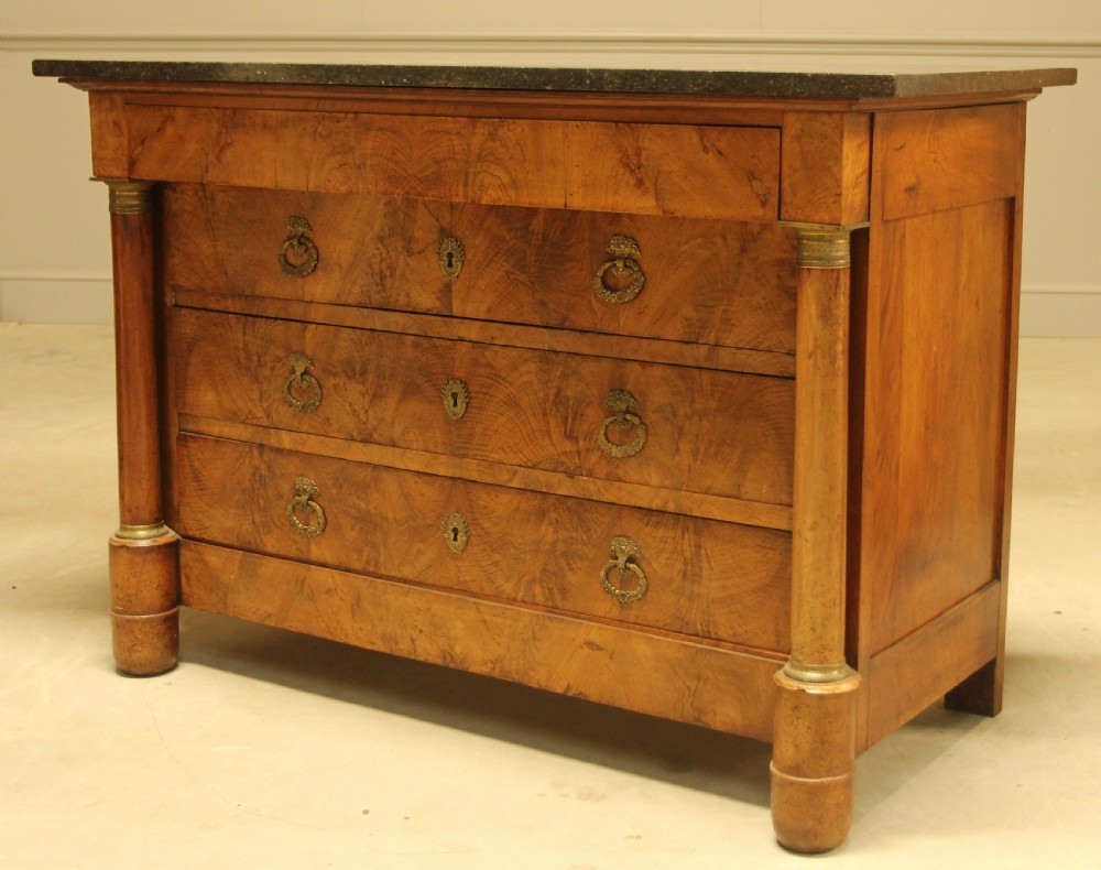 A 19th-century French burr walnut chest of drawers featuring three main drawers with brass ring handles, architectural side columns, and a dark marble top. View V