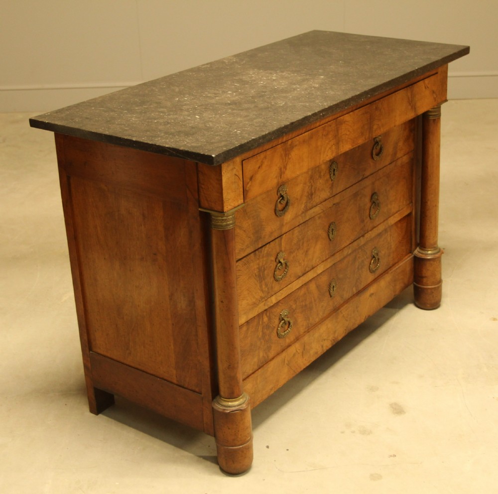 A 19th-century French burr walnut chest of drawers featuring three main drawers with brass ring handles, architectural side columns, and a dark marble top. View VI