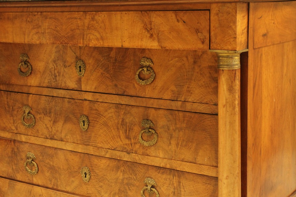 A 19th-century French burr walnut chest of drawers featuring three main drawers with brass ring handles, architectural side columns, and a dark marble top. View VIII