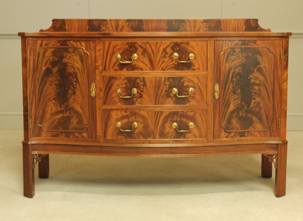 An early 20th century curl mahogany serpentine sideboard.