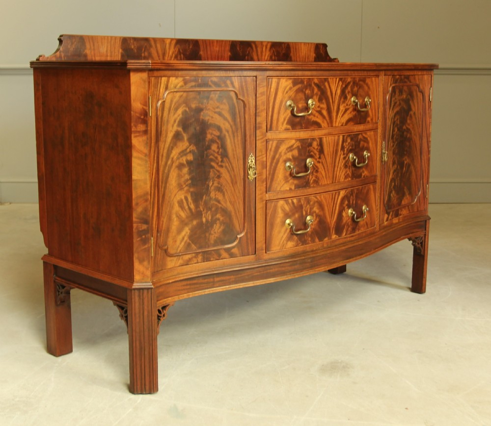 An early 20th century curl mahogany serpentine sideboard. View IV