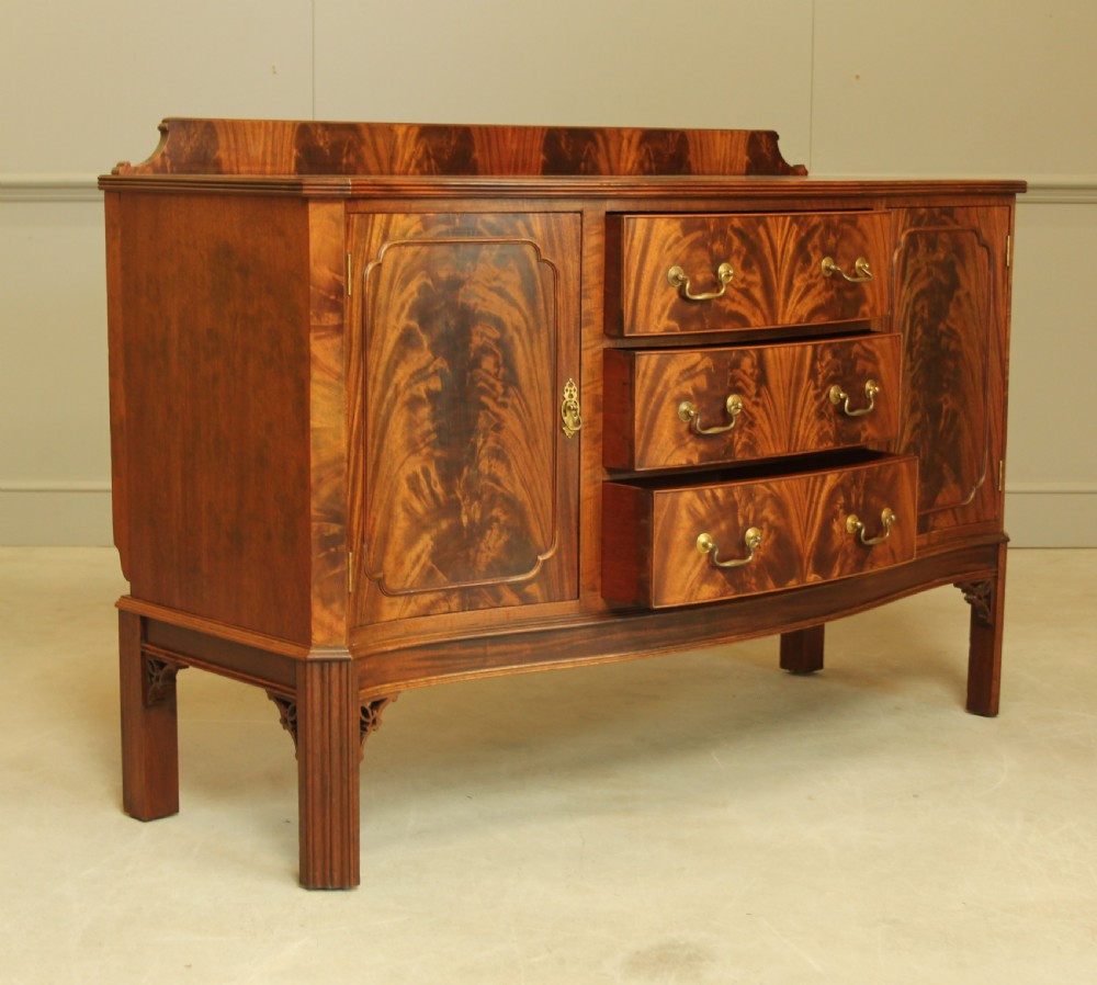 An early 20th century curl mahogany serpentine sideboard. View VII