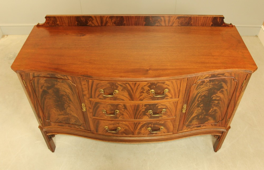 An early 20th century curl mahogany serpentine sideboard. View VIII