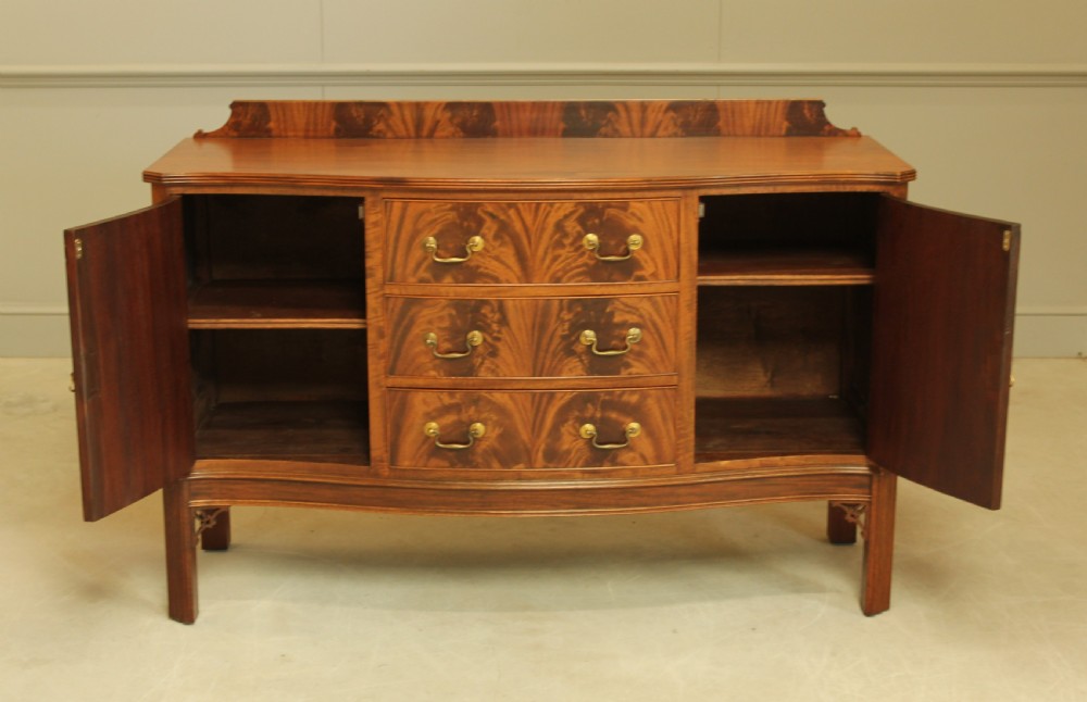 An early 20th century curl mahogany serpentine sideboard. View IX