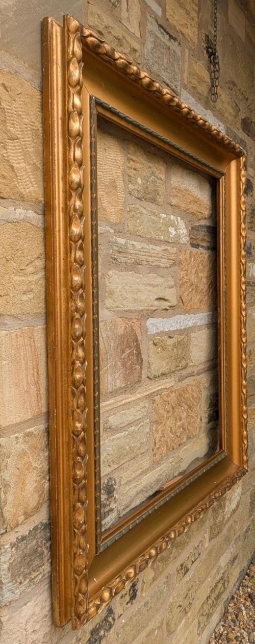 fig 1. A rectangular Empire style giltwood picture frame featuring carved outer egg-and-dart moulding and a smooth inner cove profile.
